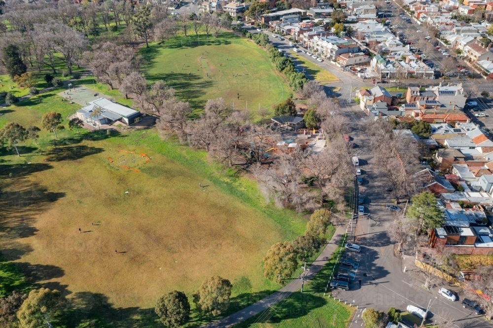 Aerial view of sporting ovals at a city park with historic homes alongside - Australian Stock Image