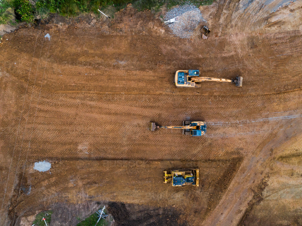 Aerial view of three earthmoving machinery on construction site for Singleton Bypass - Australian Stock Image