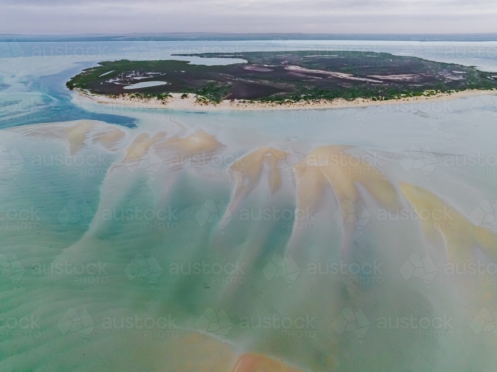 Aerial view of tidal sand bars sweeping away from an island in the middle of a calm bay - Australian Stock Image