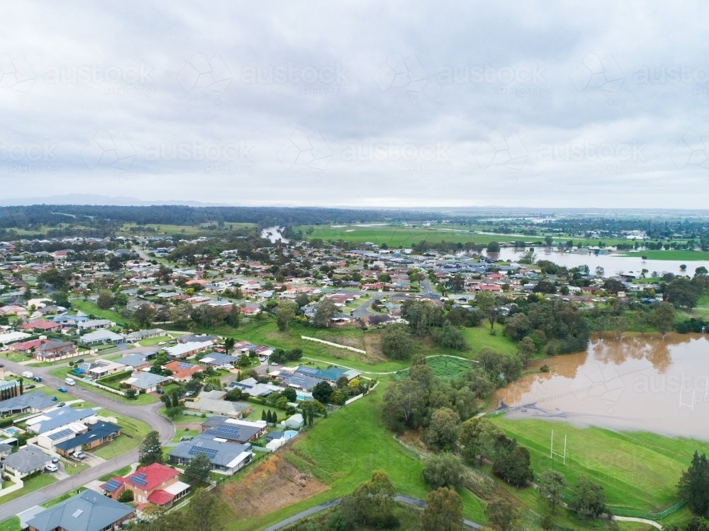 Aerial view of town in hunter valley with floodwaters from flooding river rising - Australian Stock Image