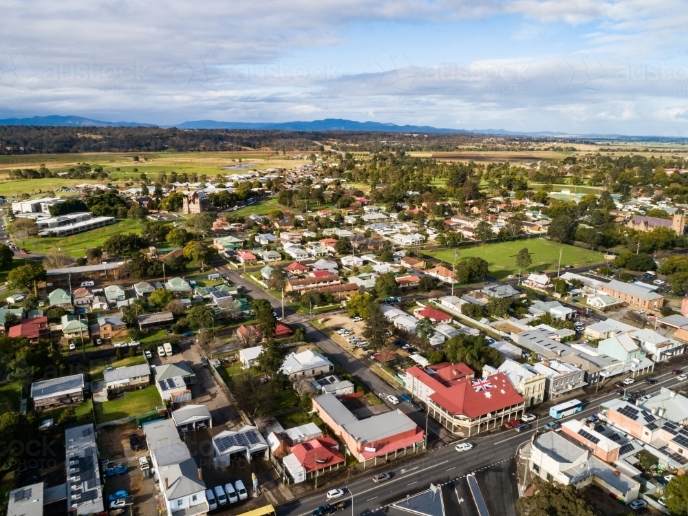 Aerial view of town looking over houses, roads and buildings towards cricket pitch - Australian Stock Image