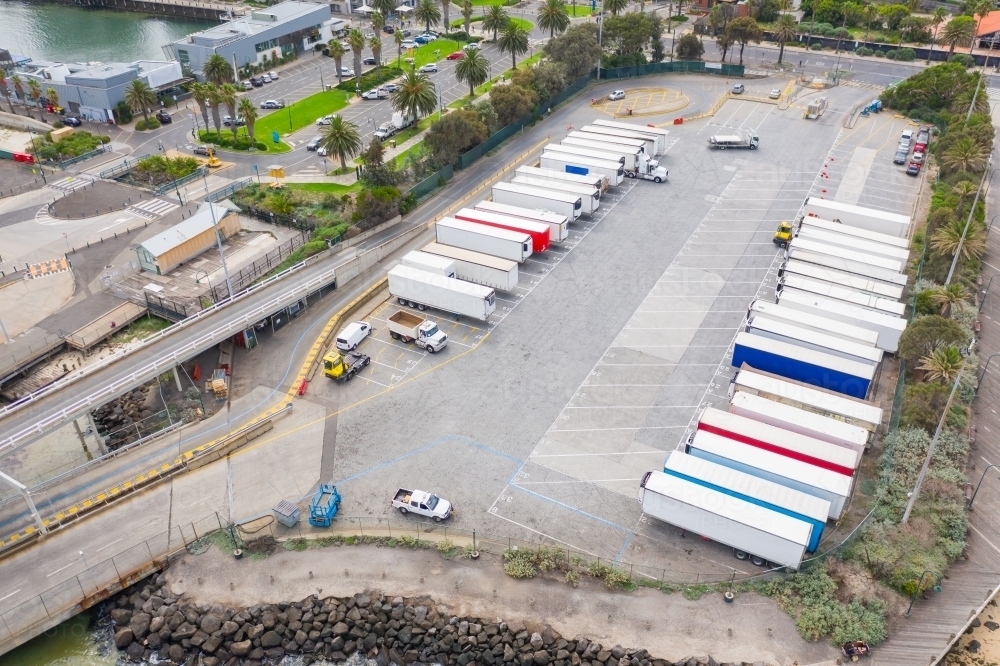 Aerial view of trucks lined up in parking bays at a ferry terminal - Australian Stock Image