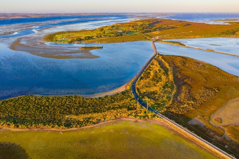 Aerial view of two coastal islands connected by a narrow road bridge - Australian Stock Image