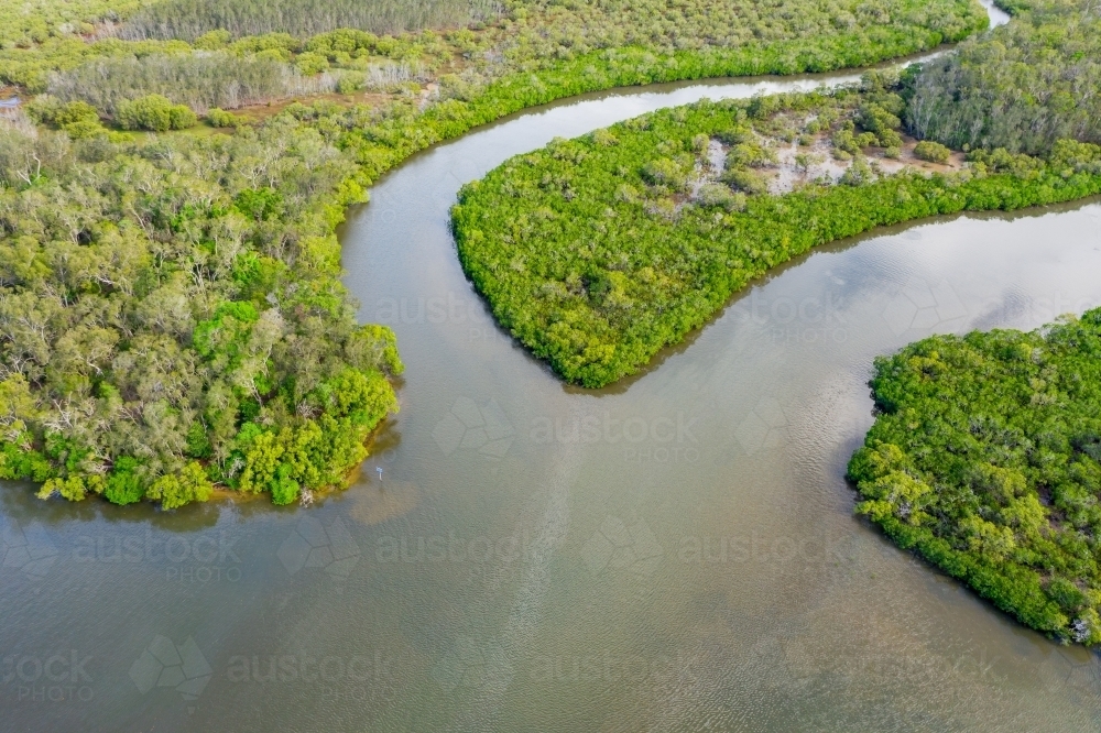 Aerial view of two creeks joining a river with lush green vegetation covering its banks - Australian Stock Image