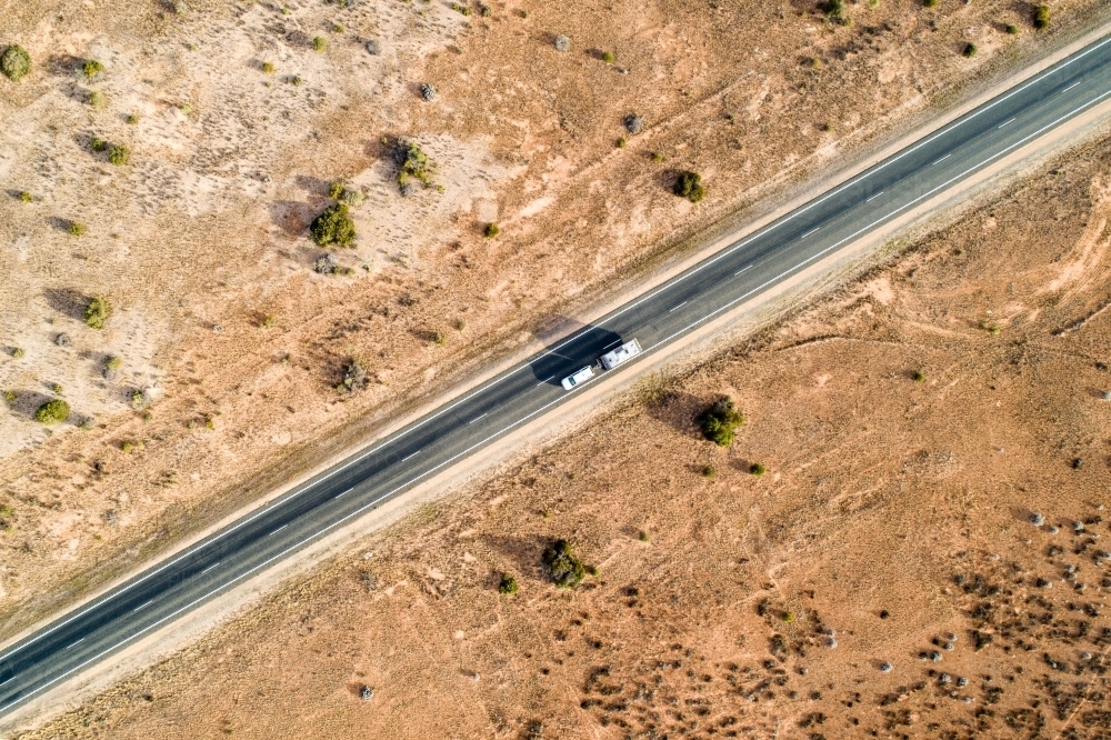 Aerial view of ute and caravan on Eyre Highway along the Nullarbor Plain - Australian Stock Image