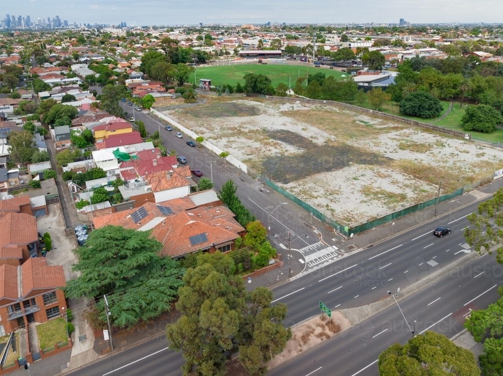 Aerial view of vacant land next to housing and a suburban intersection - Australian Stock Image