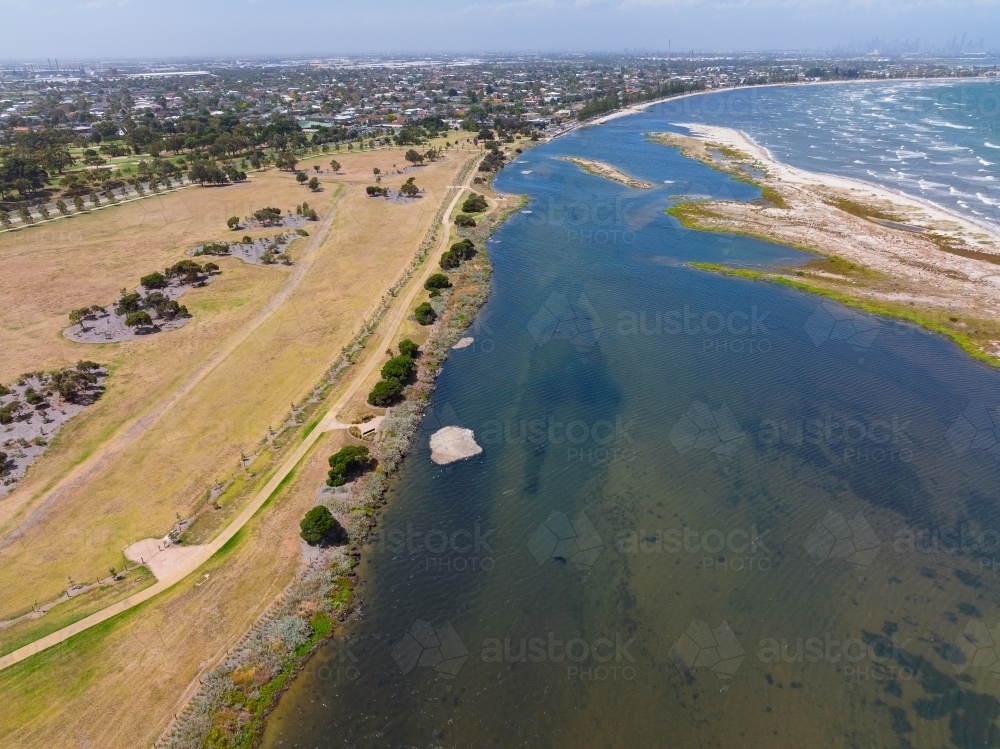 Aerial view of walking tracks through dry parkland on the edge of a coastal bay - Australian Stock Image