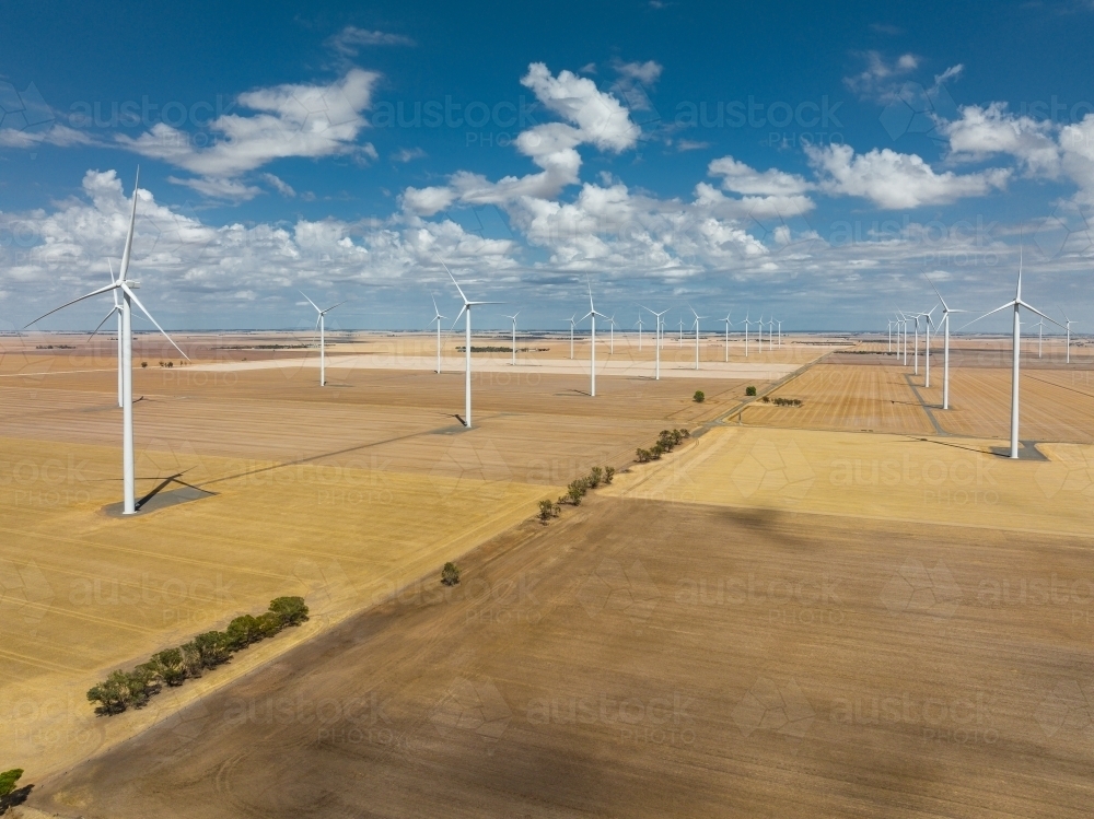 Aerial view of wind turbines scattered over rural farmland - Australian Stock Image