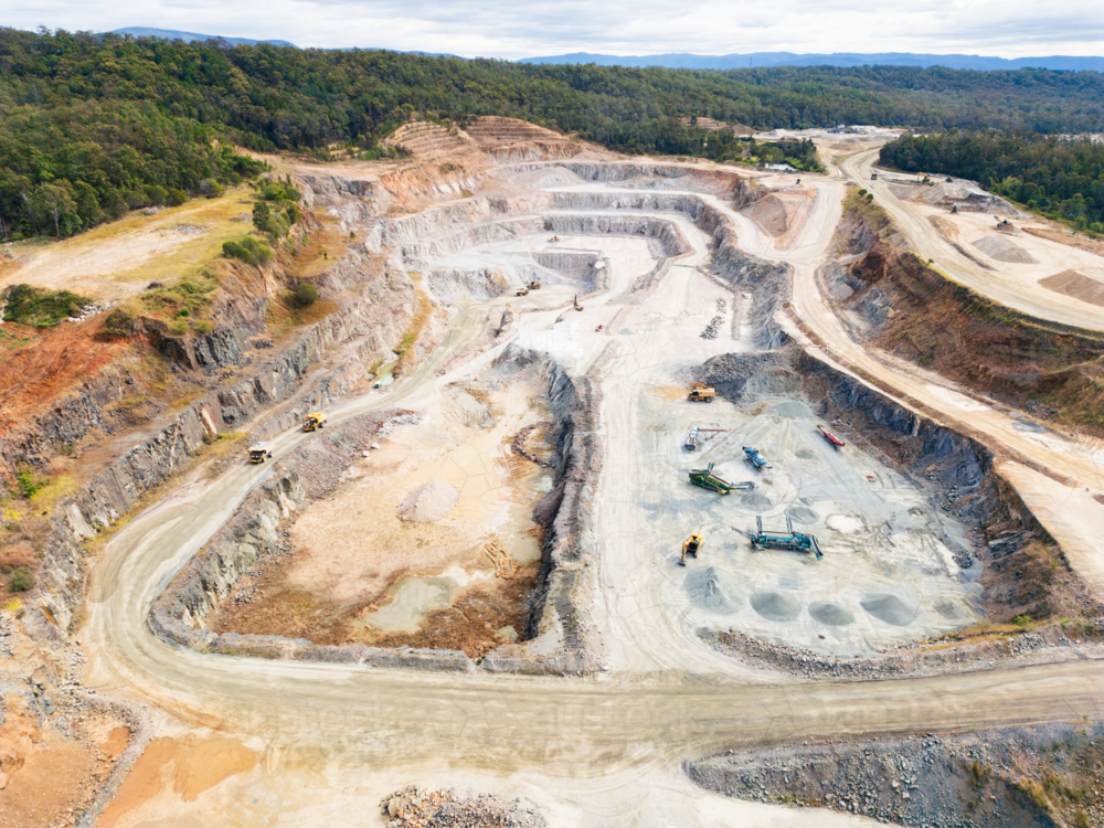 Aerial view over a quarry pit with machinery haulage roads - Australian Stock Image