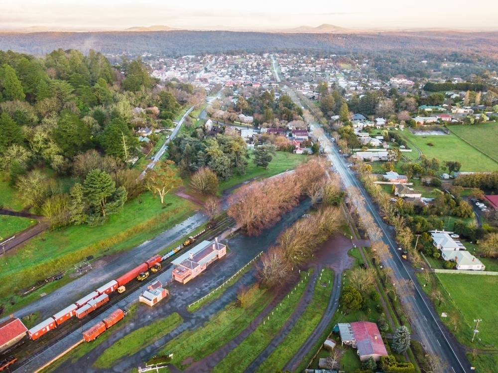 Aerial view over a railway station alongside a road leading into a country town - Australian Stock Image