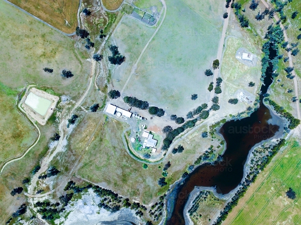 Aerial view over farm with dam, river, and farm buildings - Australian Stock Image