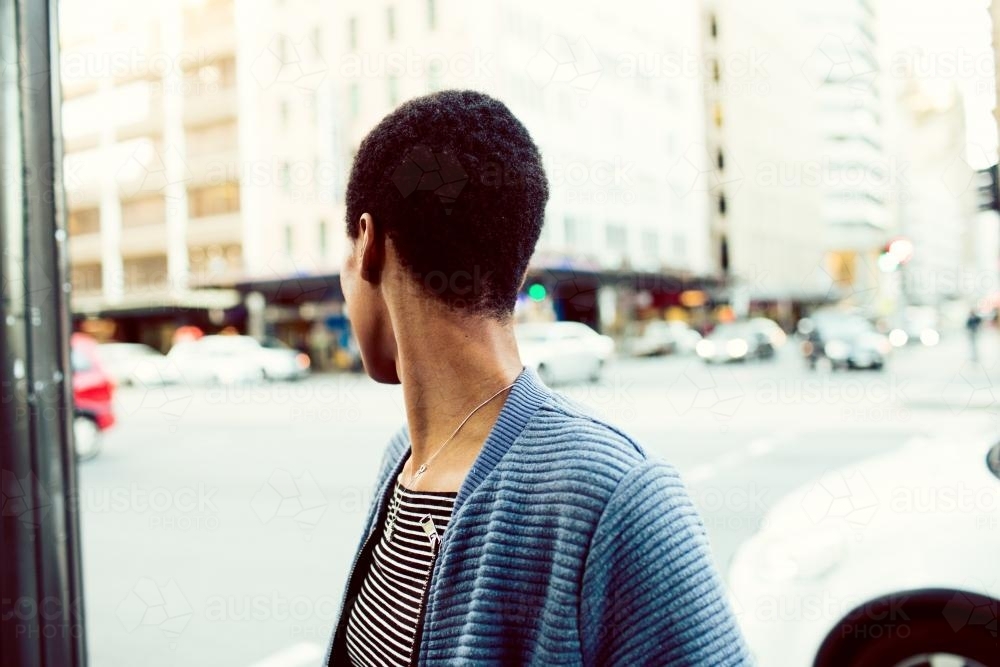 African woman looking over her shoulder in the street - Australian Stock Image