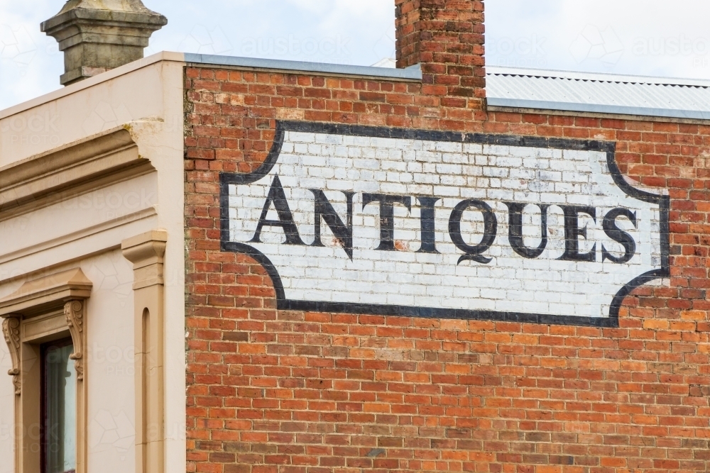 An antique sign painted onto the side of a brick wall of an historic building - Australian Stock Image