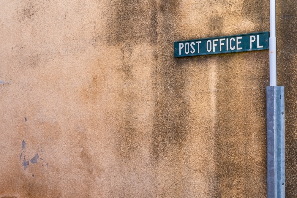 An coloured street sign attached to an discoloured wall of a laneway - Australian Stock Image