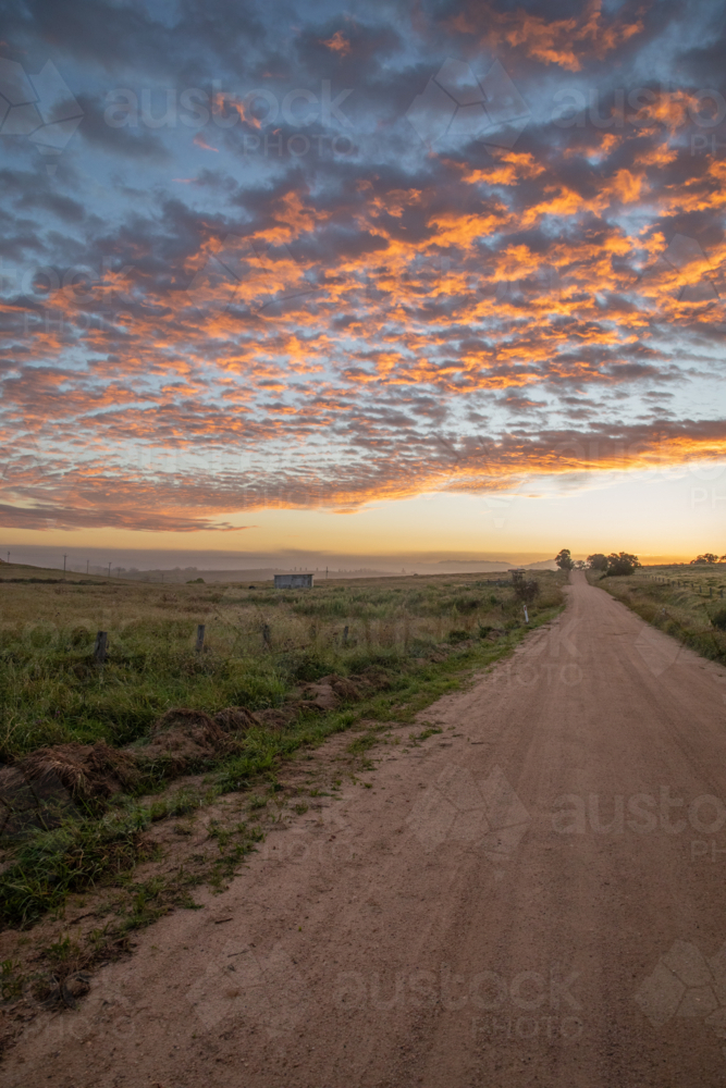 An early morning, a colourful dawn sky, and a country road - Australian Stock Image