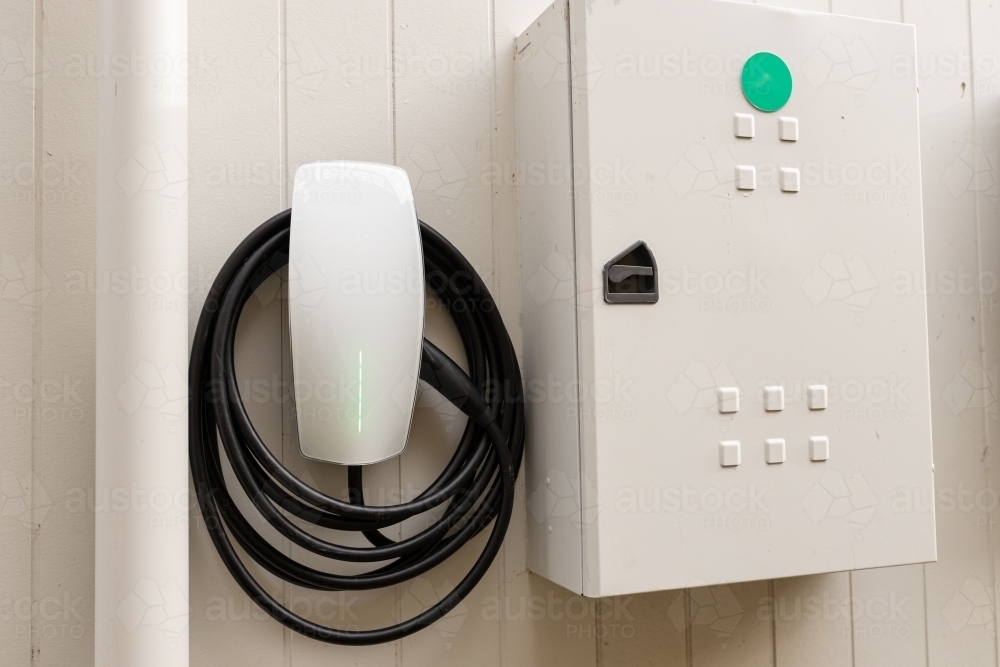 An electric vehicle car charger on the wall of a house with the switch break box next to it - Australian Stock Image