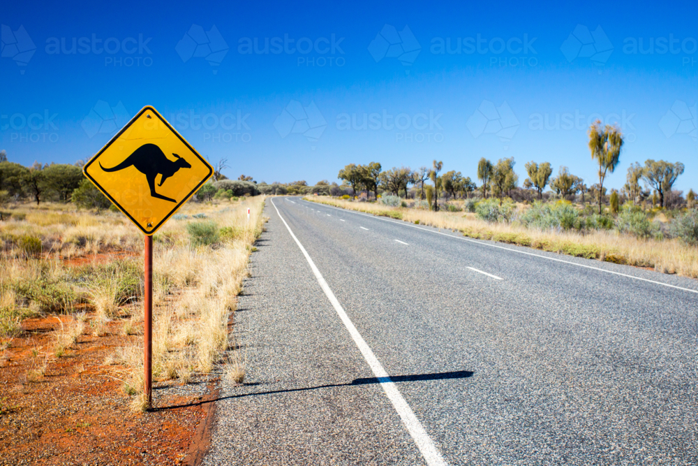 An iconic warning road sign for kangaroos near Uluru in Northern Territory, Australia - Australian Stock Image