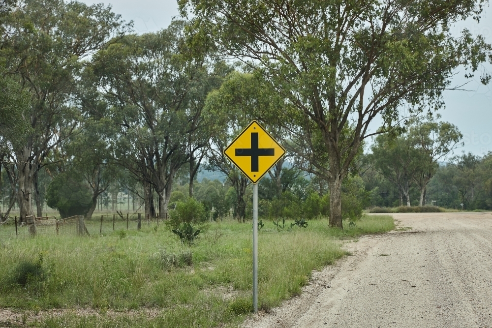 An intersection signage on gravel country road by paddock - Australian Stock Image