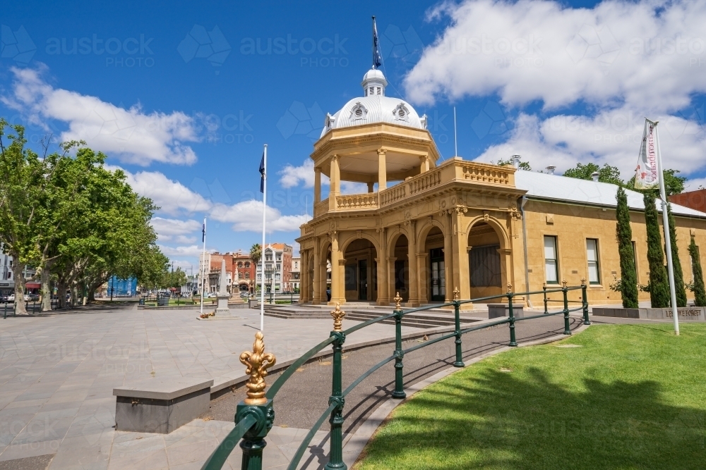 An ornate metal railing leading towards a grand historic RSL building - Australian Stock Image