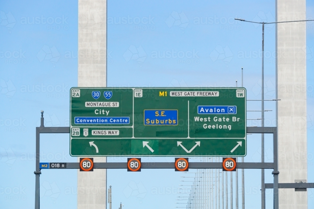 An overhead traffic sign in front of bridge pylons - Australian Stock Image