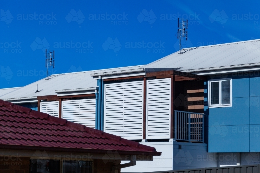 antenna aerials on roof of blue house building - Australian Stock Image