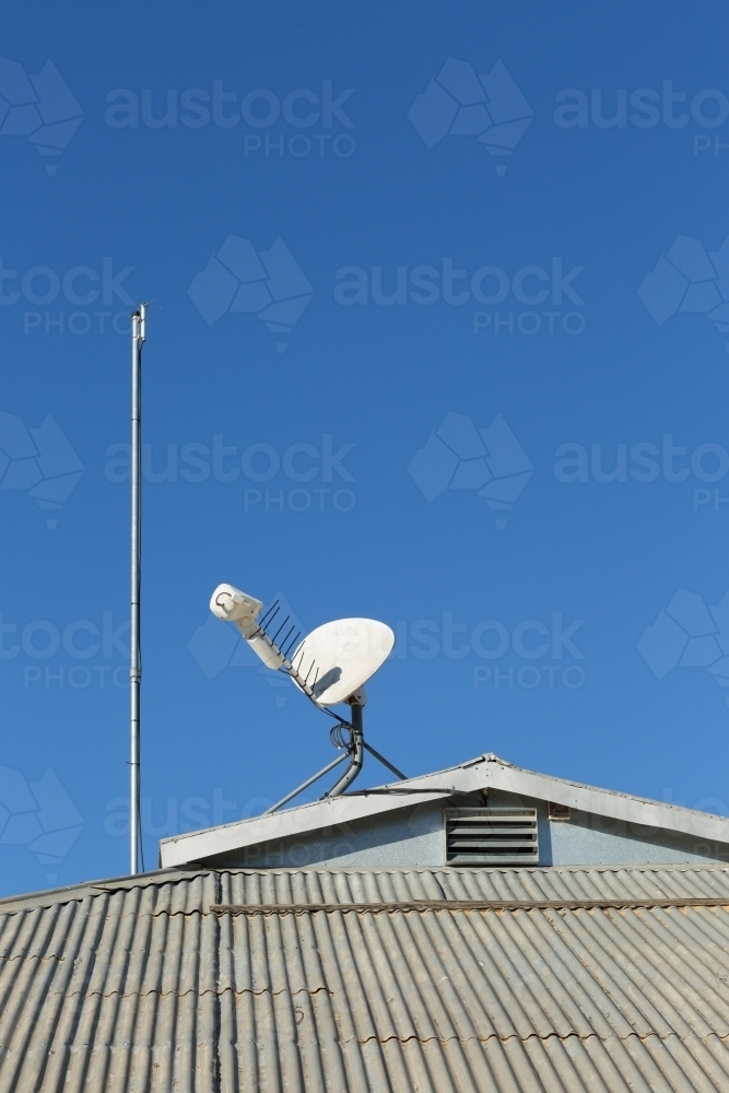 Antenna and satellite dish on tin roof - Australian Stock Image