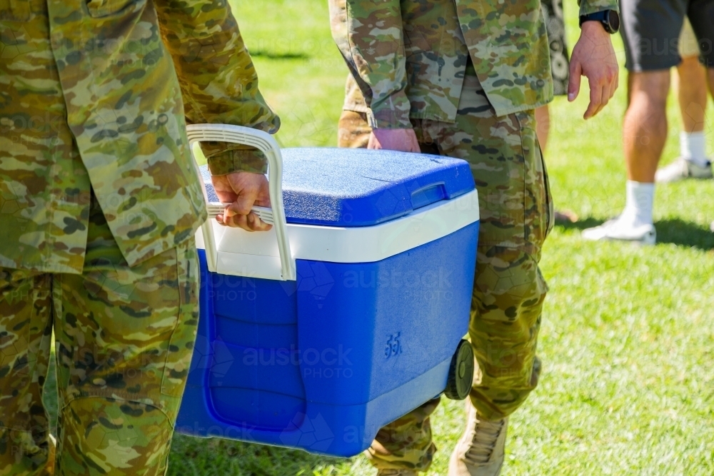 Army men carrying an esky full of ice blocks at army event - Australian Stock Image