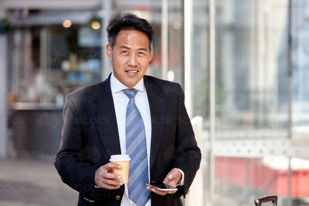 Asian businessman in city - Australian Stock Image