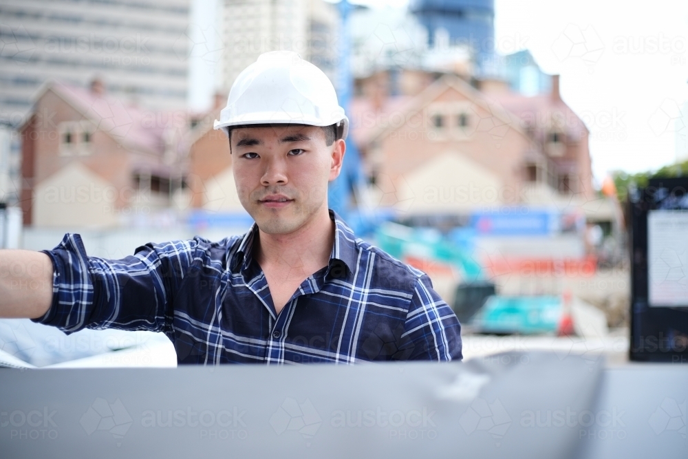 Asian man wearing hard hat - Australian Stock Image