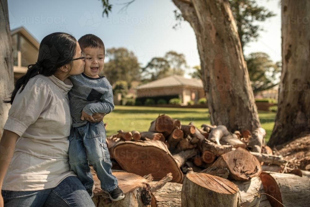 Asian mum with her mixed race boys in front of their country home - Australian Stock Image