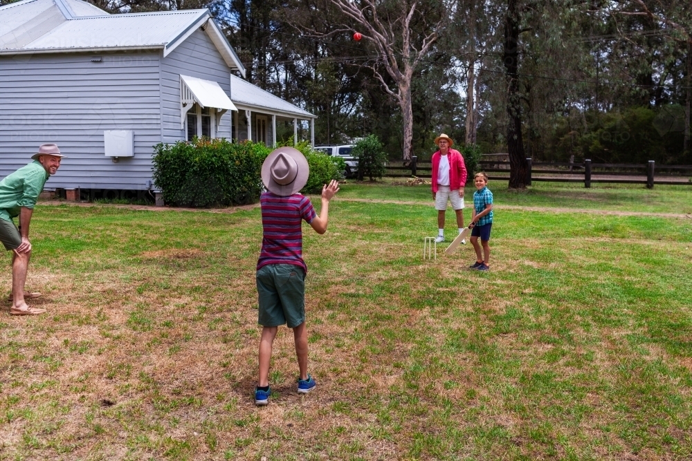 Image of Aussie boys playing backyard cricket with their grandfather ...