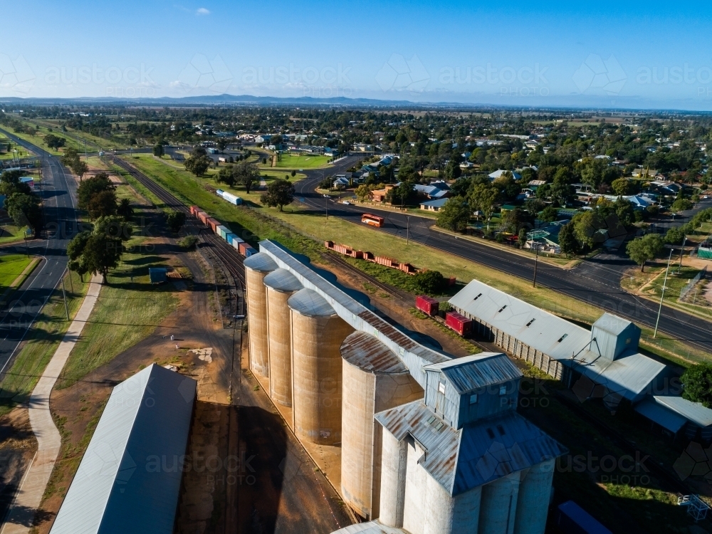 Aussie country town scene in Narromine of grain silos beside railway and freight train - Australian Stock Image