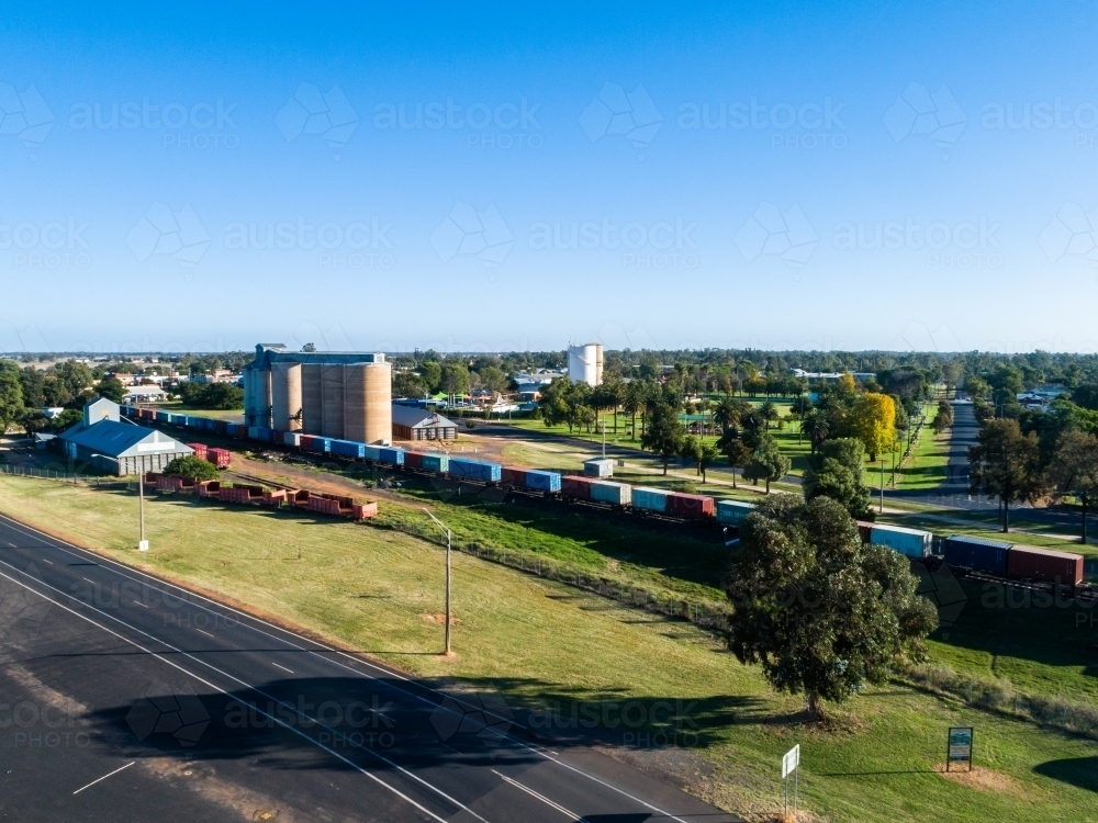 Aussie country town scene in Narromine of grain silos beside railway and freight train - Australian Stock Image