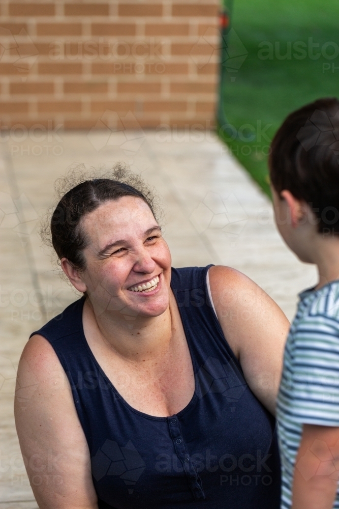 Image of Aussie mum laughing with her son outside in backyard ...