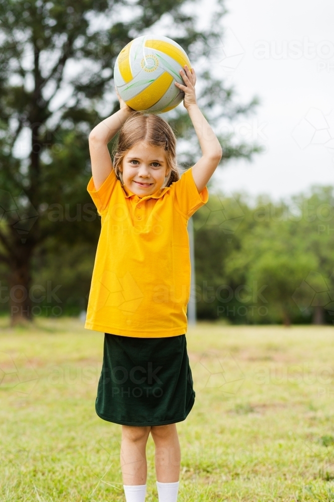 Aussie school girl throwing ball during sports game outside - Australian Stock Image