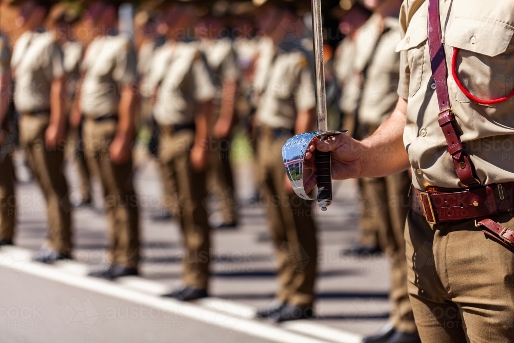 Australian army soldier with sword drawn for Freedom of Entry ceremony beside troops - Australian Stock Image