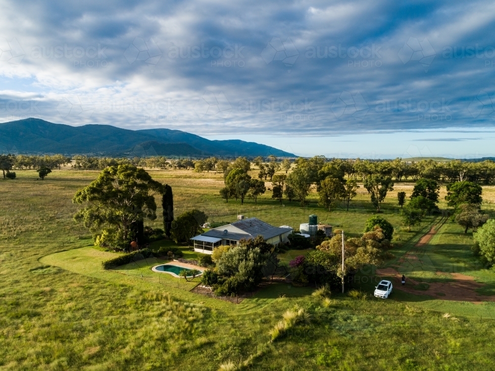 Australian farm landscape with farmers house among green paddocks - Australian Stock Image