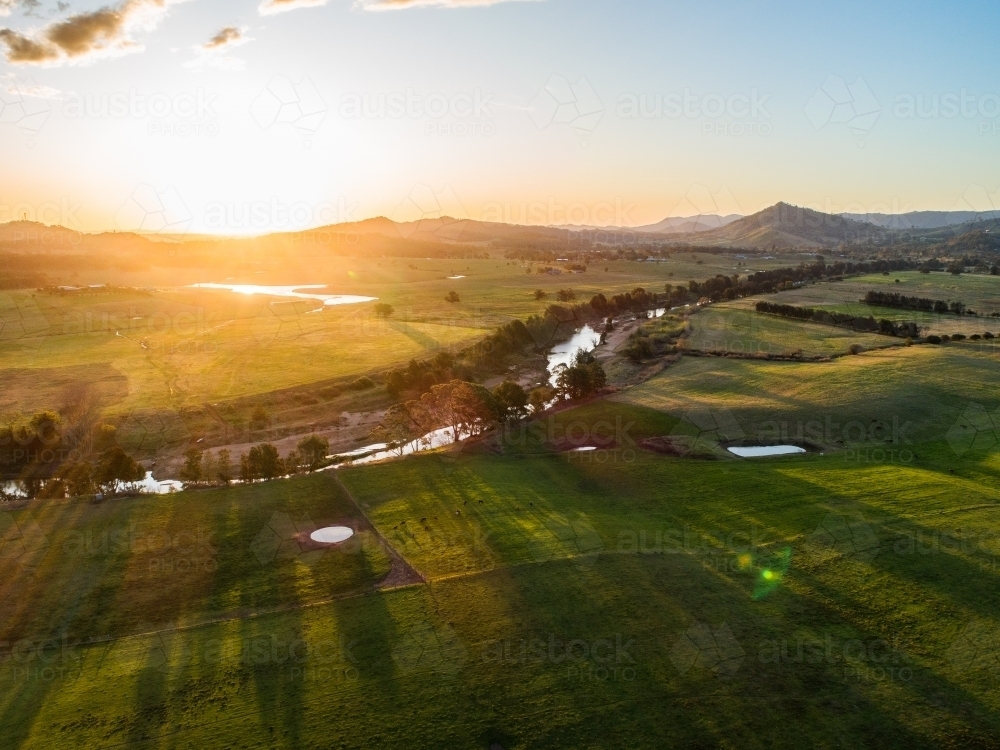 Image of Australian farmland with river flowing through it at sunset ...