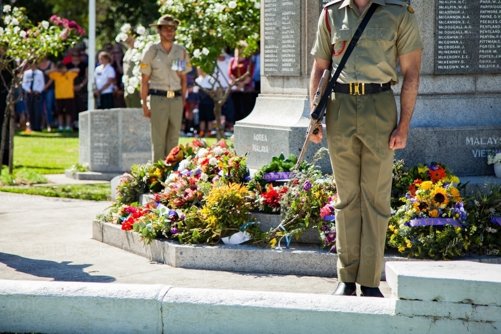 Australian soldiers standing around a cenotaph at an ANZAC Day service - Australian Stock Image