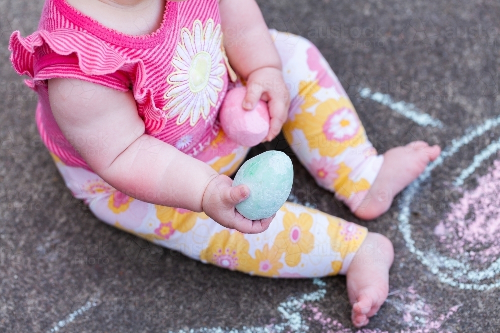 Baby drawing with chalk on concrete - childhood - Australian Stock Image