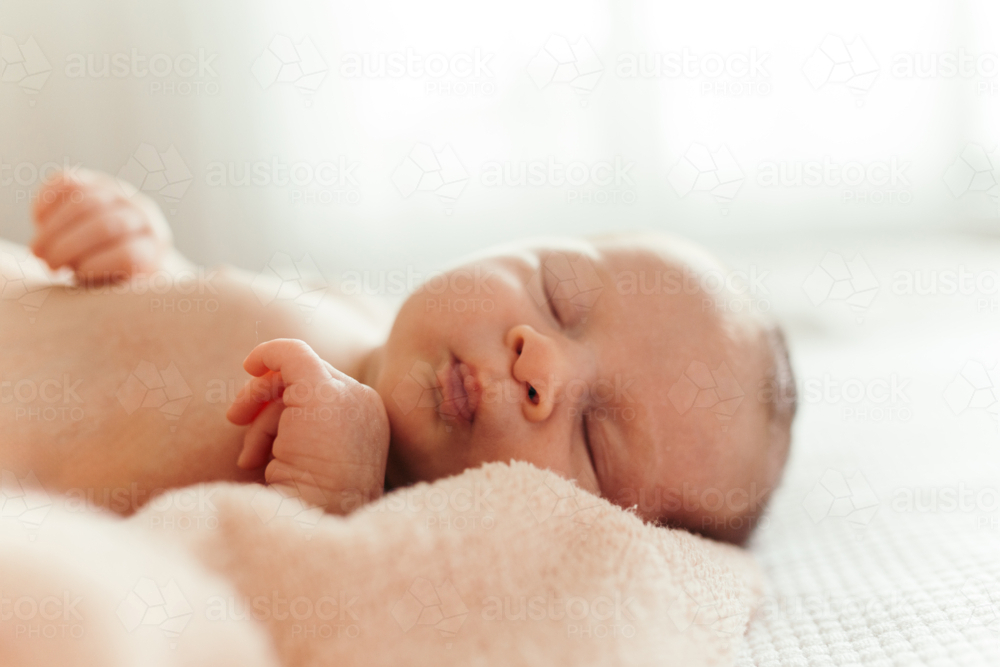 baby girl wrapped in a blanket sleeping. - Australian Stock Image