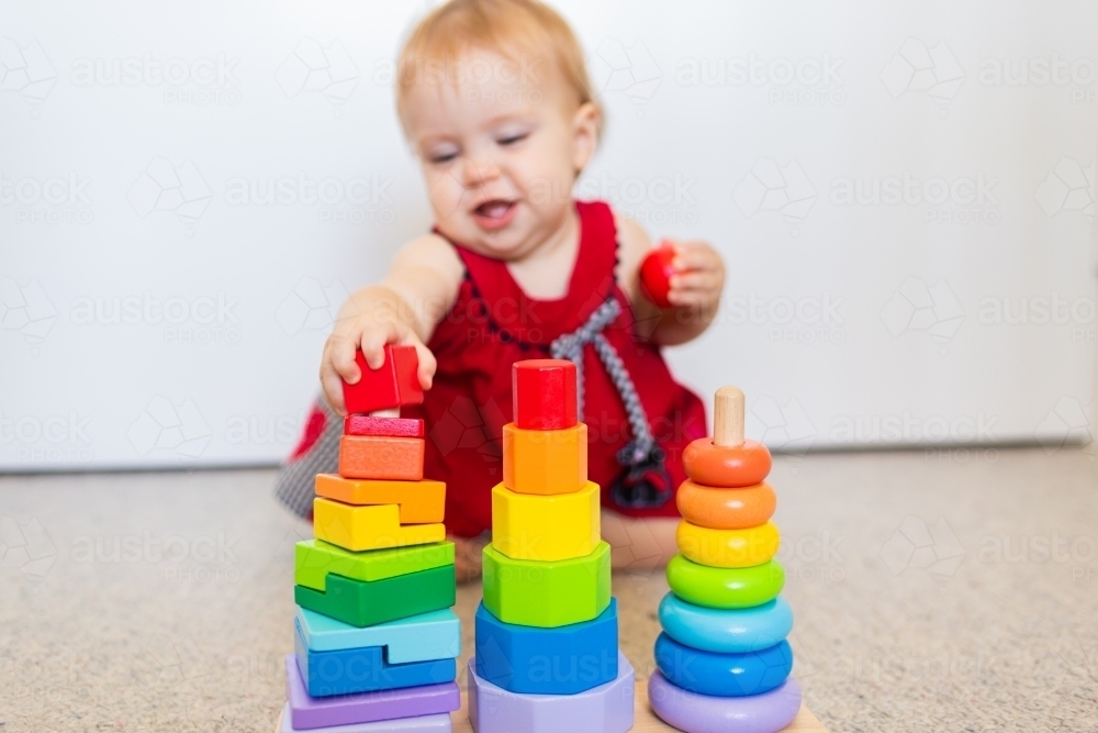 image-of-baby-sitting-on-floor-playing-with-colourful-stacking-fine