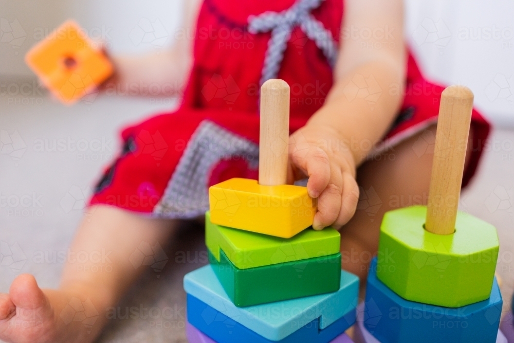 image-of-baby-sitting-on-floor-playing-with-colourful-stacking-fine