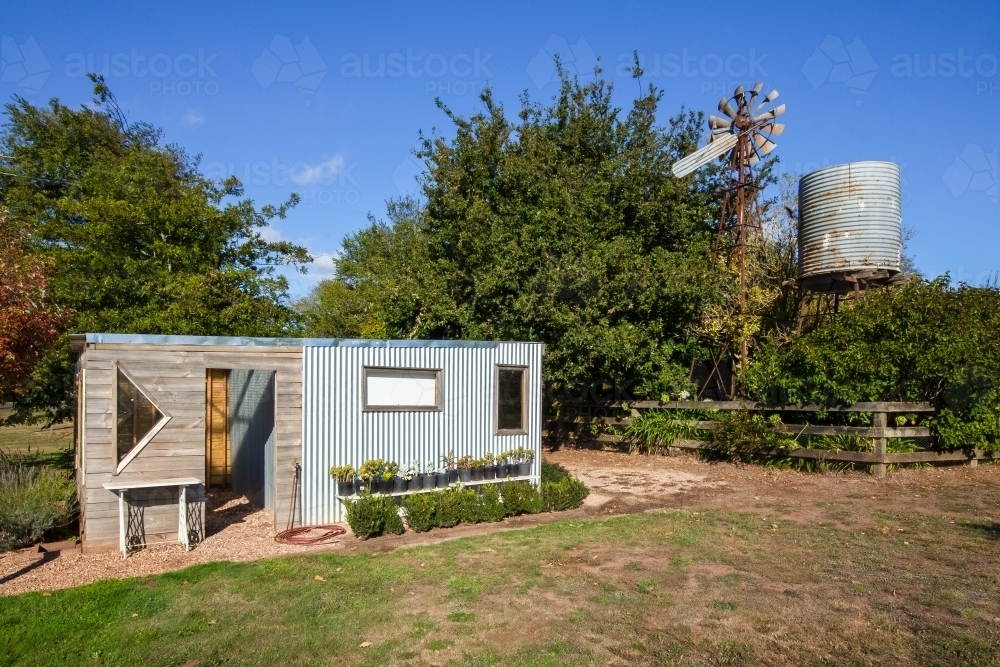 Backyard office near an old windmill and water tank - Australian Stock Image