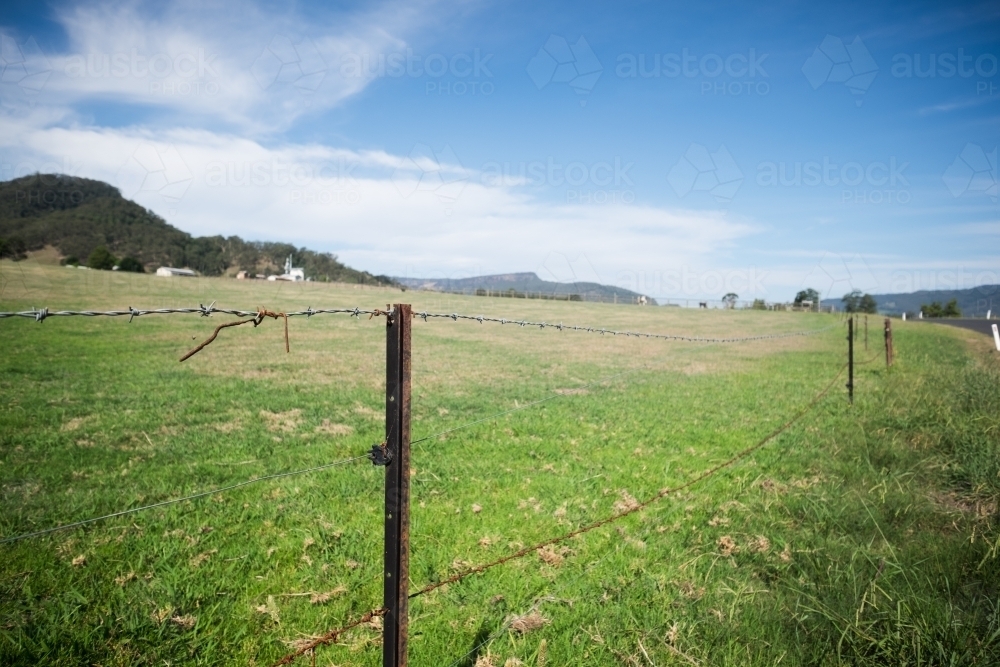 barbed wire fencing on farmland - Australian Stock Image