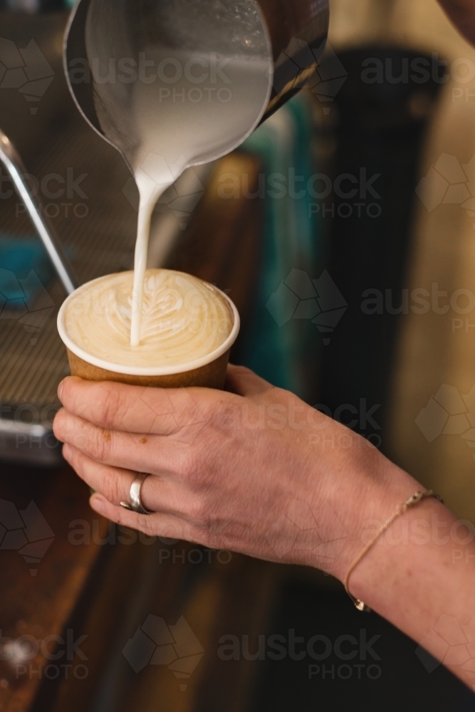 barista making coffee, pouring the milk - Australian Stock Image