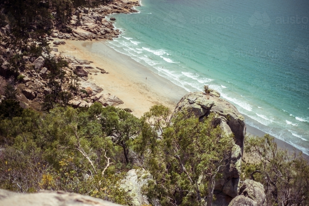 Beach coastal view from high vantage point with gentle waves lapping at the shore - Australian Stock Image