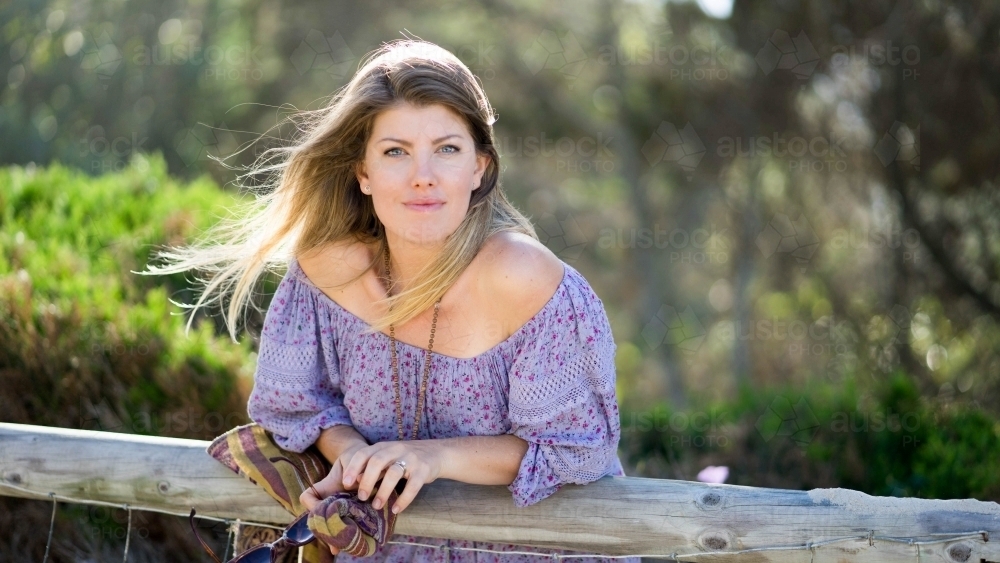 Beach girl leaning on railing looking at camera - Australian Stock Image