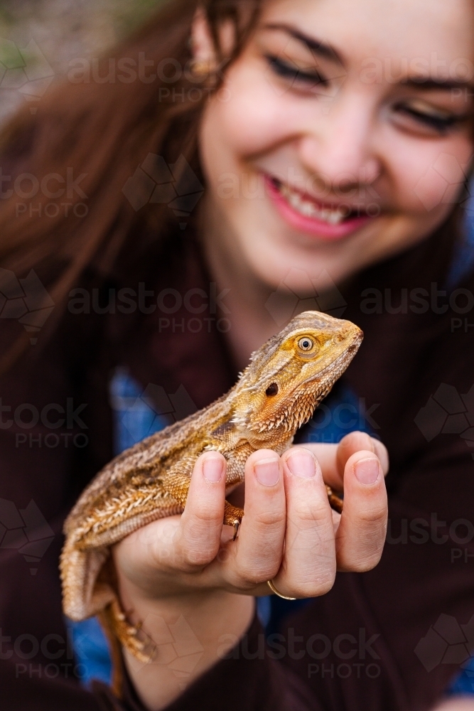 Bearded dragon lizard sitting on young lady - Australian Stock Image