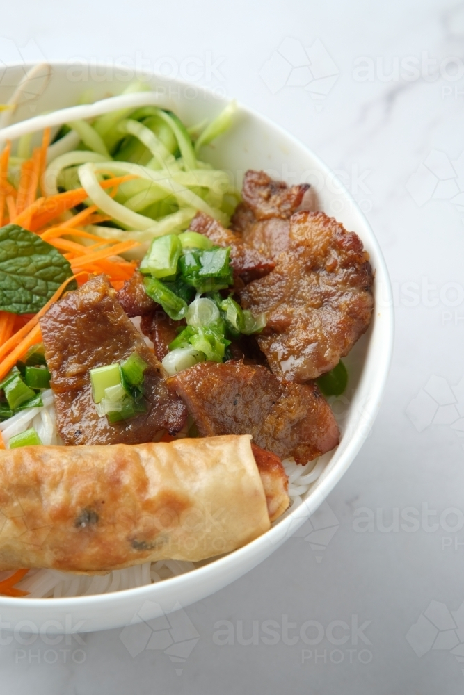 Beef noodle salad topped with fried lumpia - Australian Stock Image